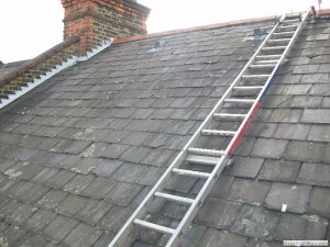 project for slate roofing in manchester - image shows our roofer setting up his ladder on roof